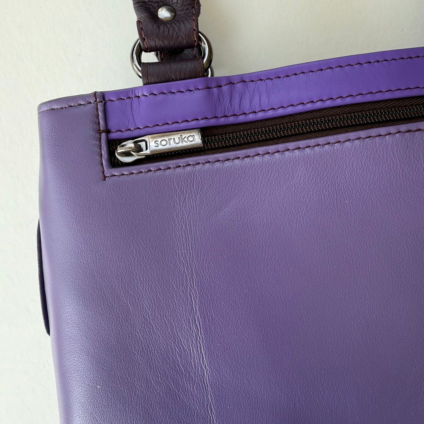 close-up of Purple handbag with a closed zipper pocket