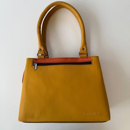 Yellow handbag with a zipper pocket on a light background