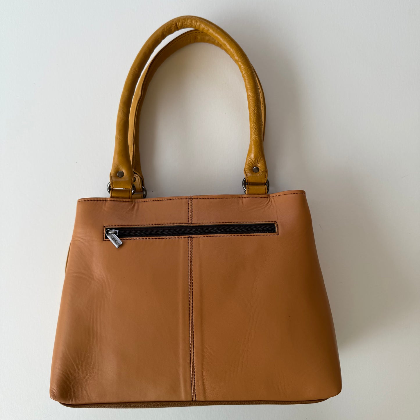 back view of handbag with beige leather  backing