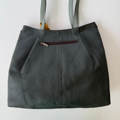 back view of tote with Dark gray leather and a zipper pocket on a light background
