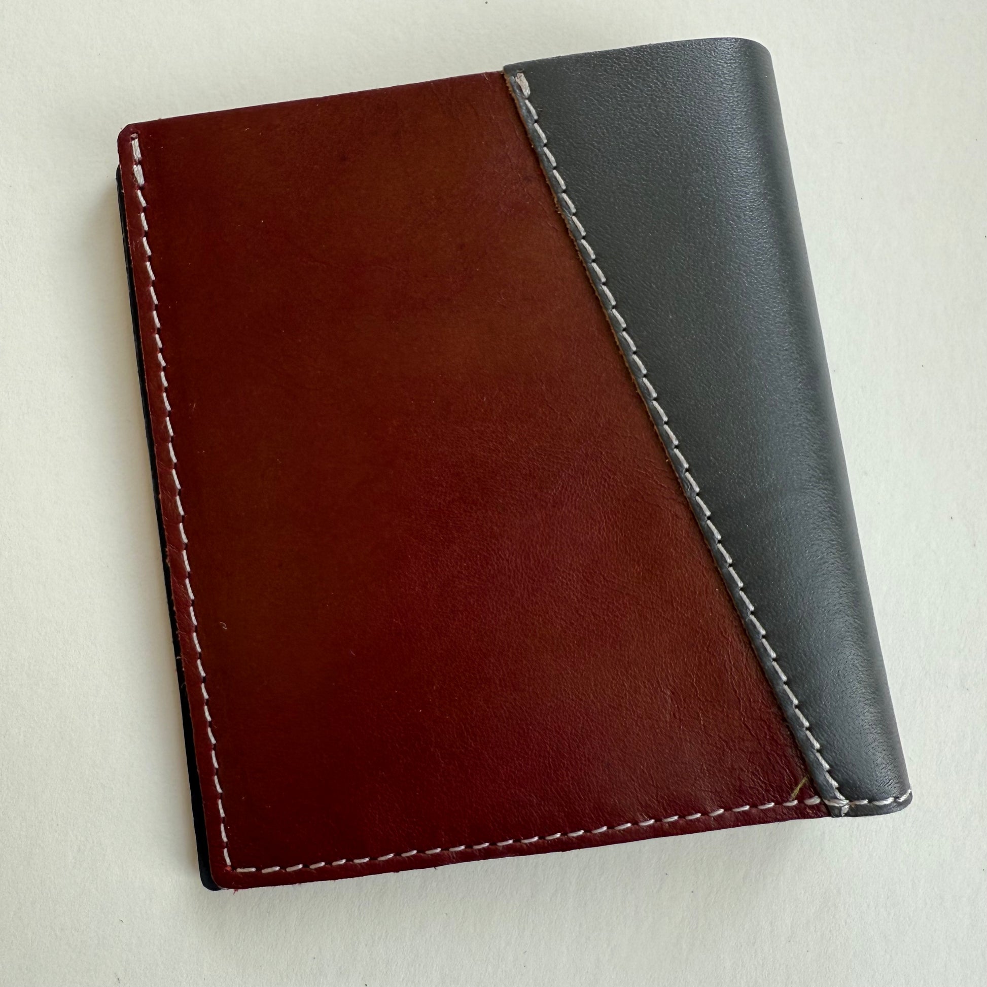 grey and brown leather wallet with white stitching