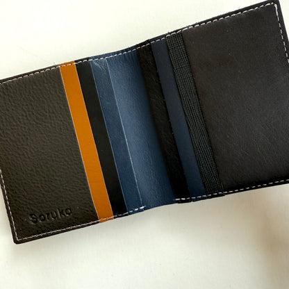interior view of Black leather wallet with multi-colored card slots on a white background