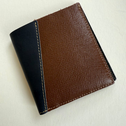 Two-tone brown and DARK NAVY leather wallet on a light beige background