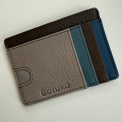 Leather cardholder with brown and blue accents on a light gray background