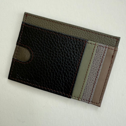 Two-tone leather cardholder with black and gray sections on a light gray background
