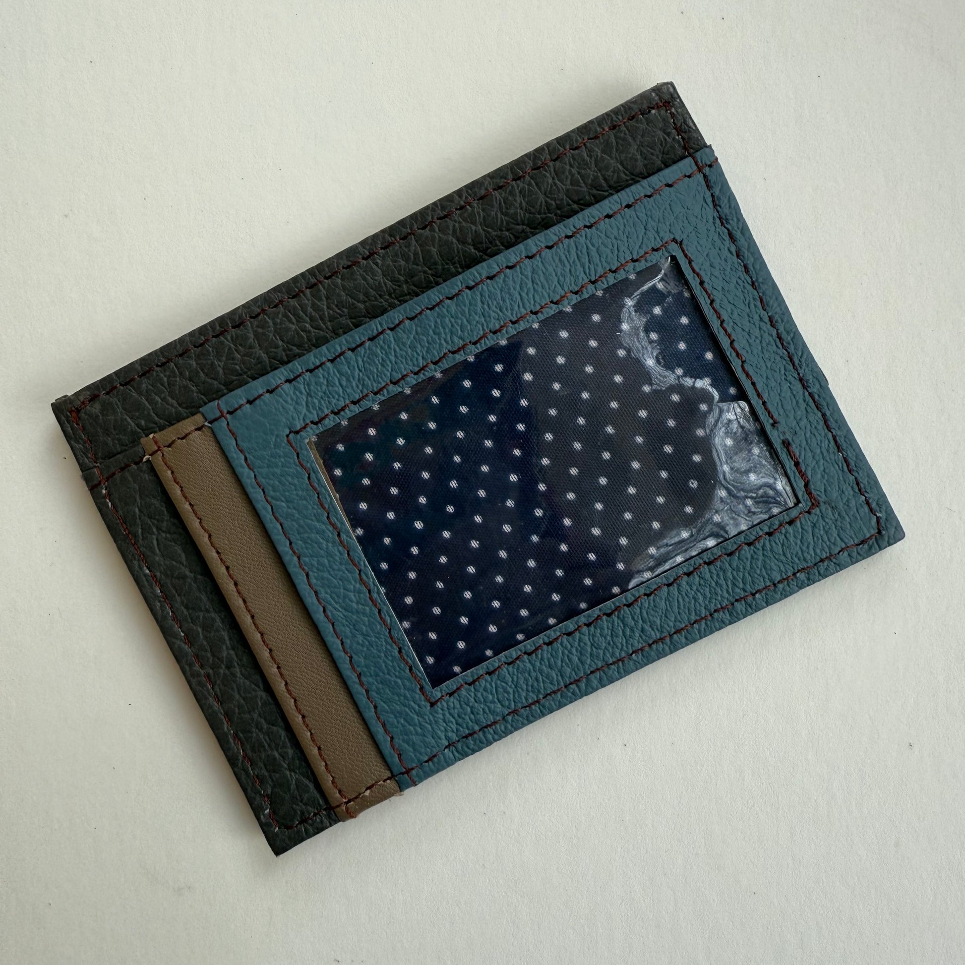 Blue cardholder with a clear ID pocket on a light gray background