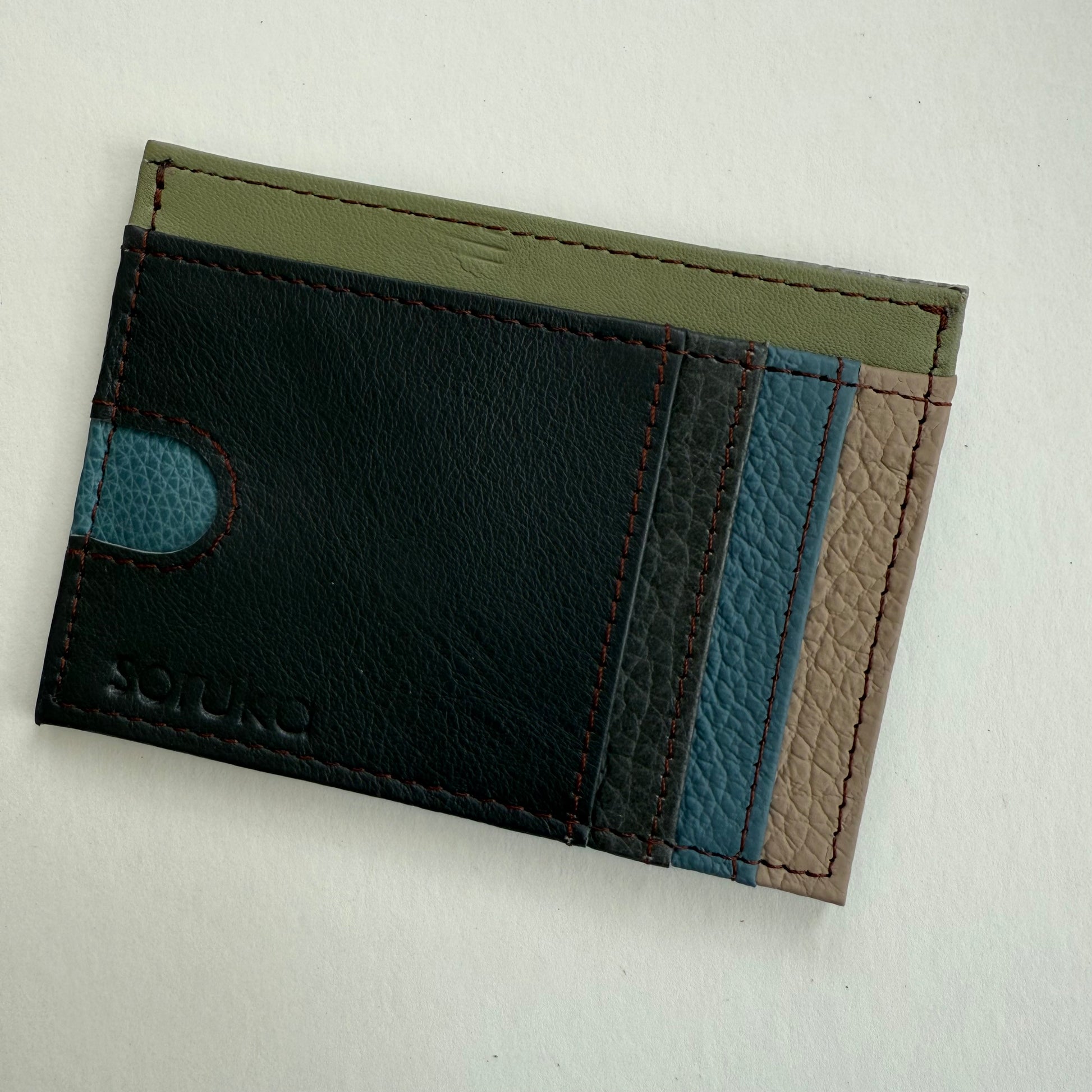 brown, blue, and green leather wallet  on a light gray background