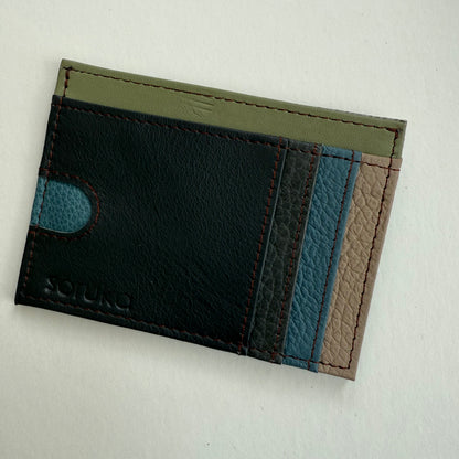brown, blue, and green leather wallet  on a light gray background