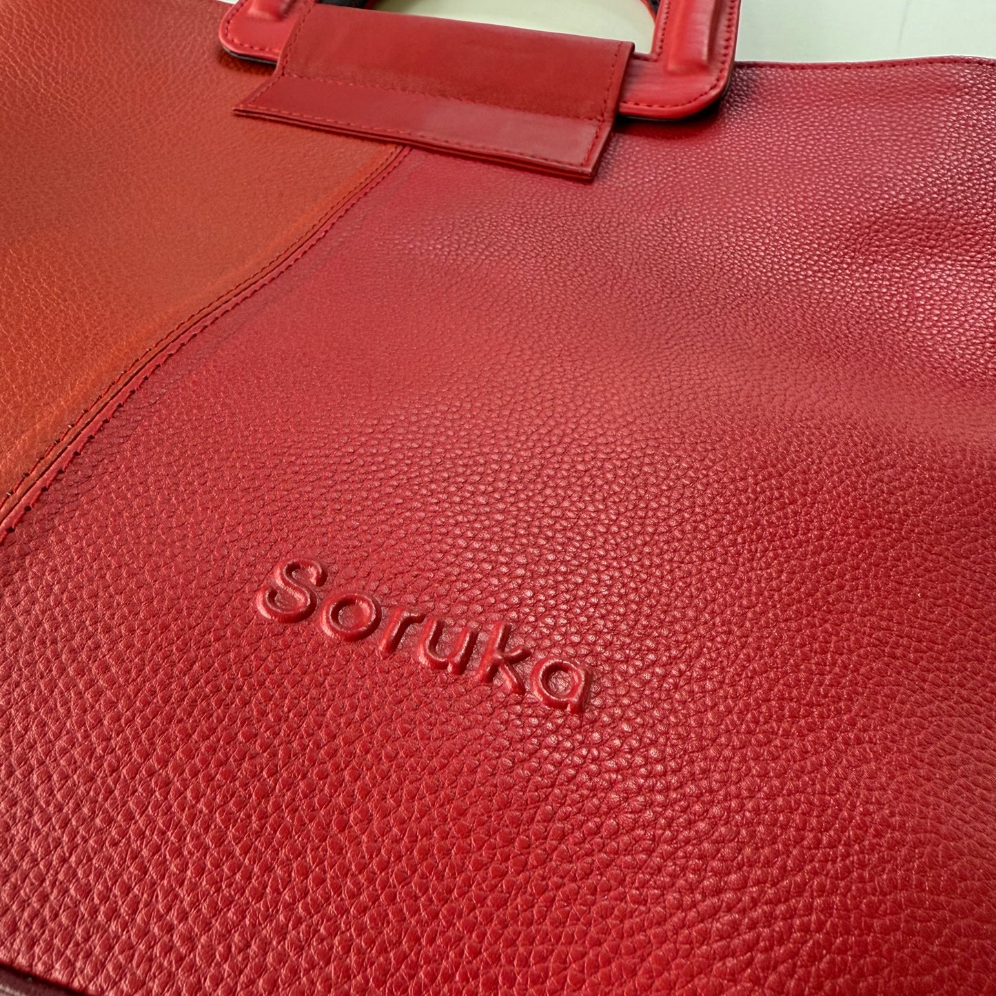 Red leather bag with 'Soruka' branding on a white background