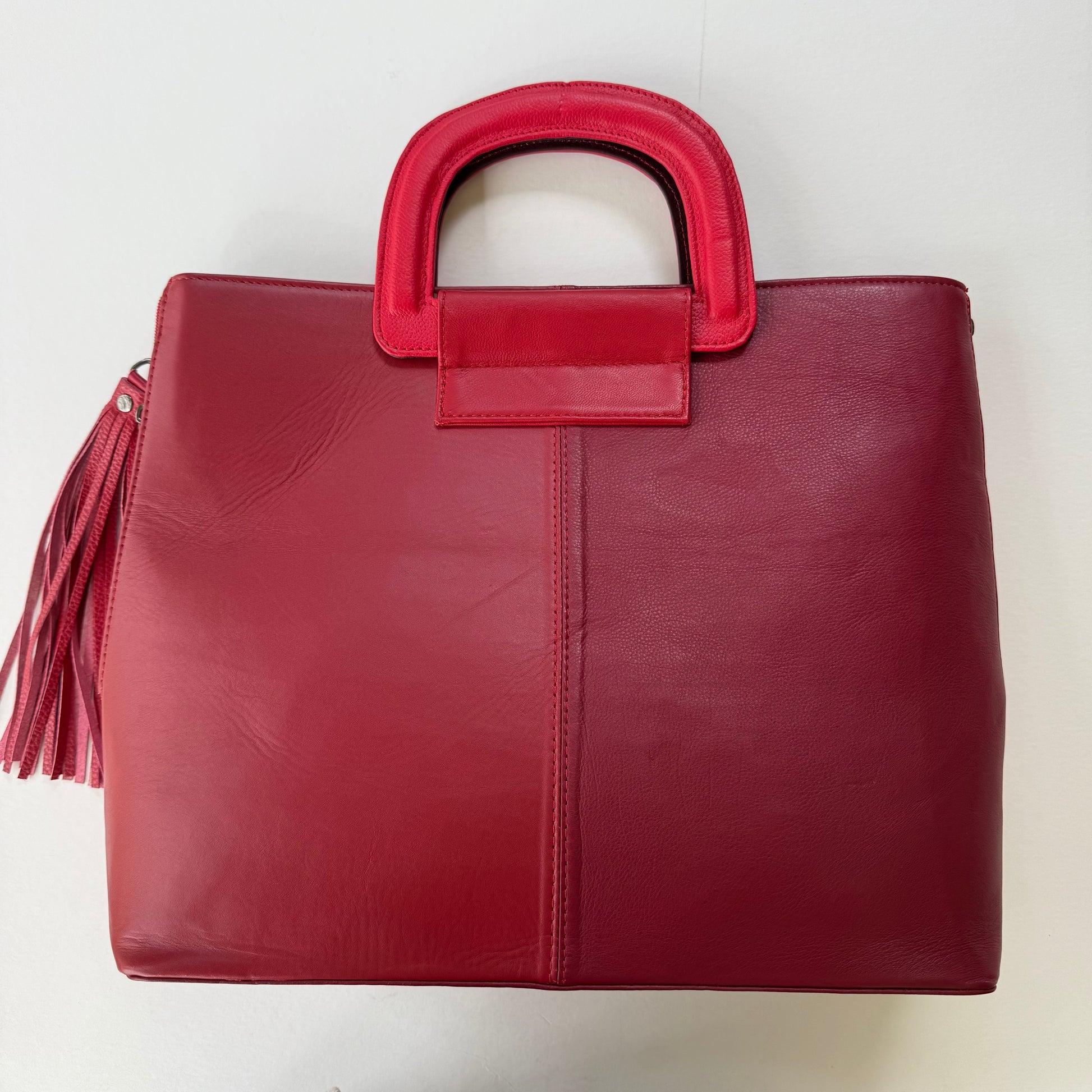 back view of Red tote bag with a tassel on a white background