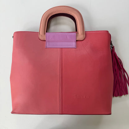 tote bag in pink hues with light pink handles and bright pink tassel shown on a light background