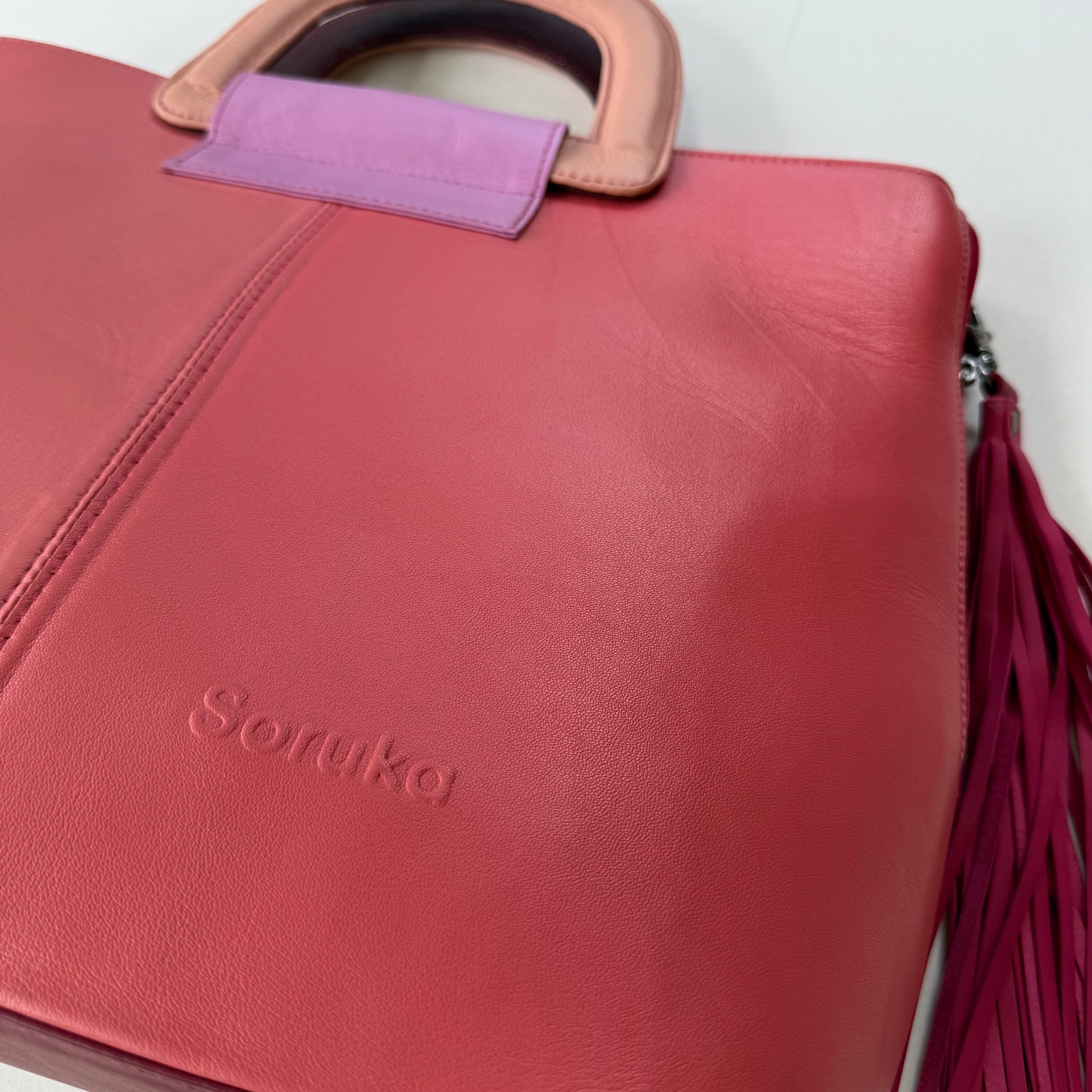 close-up of bottom corner of pink tote with tassel