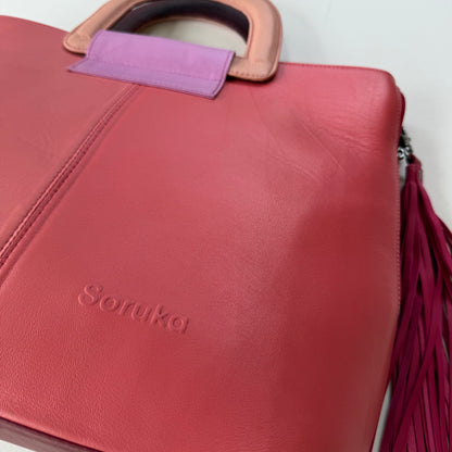 close-up of bottom corner of pink tote with tassel