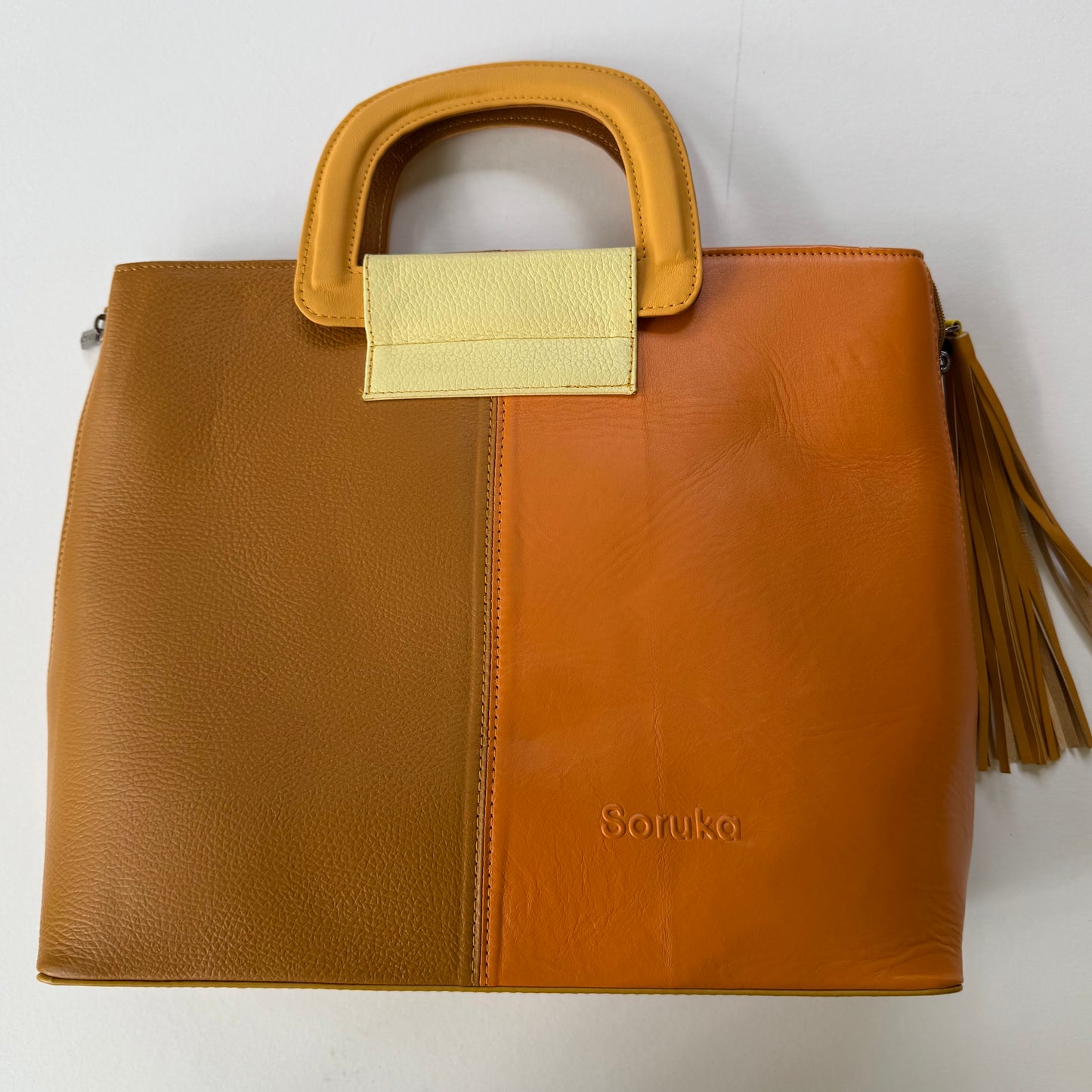 tote back in mustard yellow hues with yellow handles and dark yellow tassel