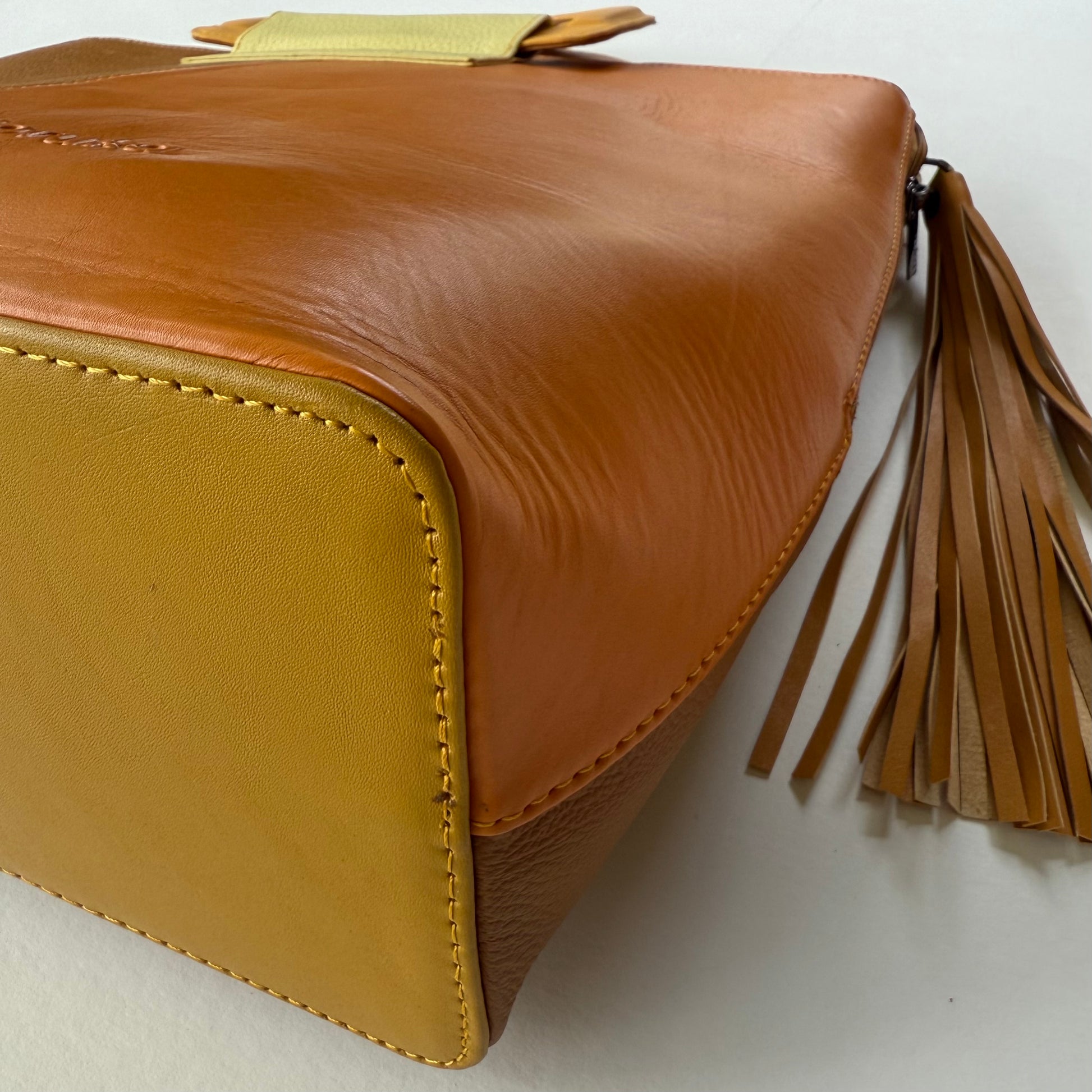 close-up of bottom corner of yellowish-brown tote bag