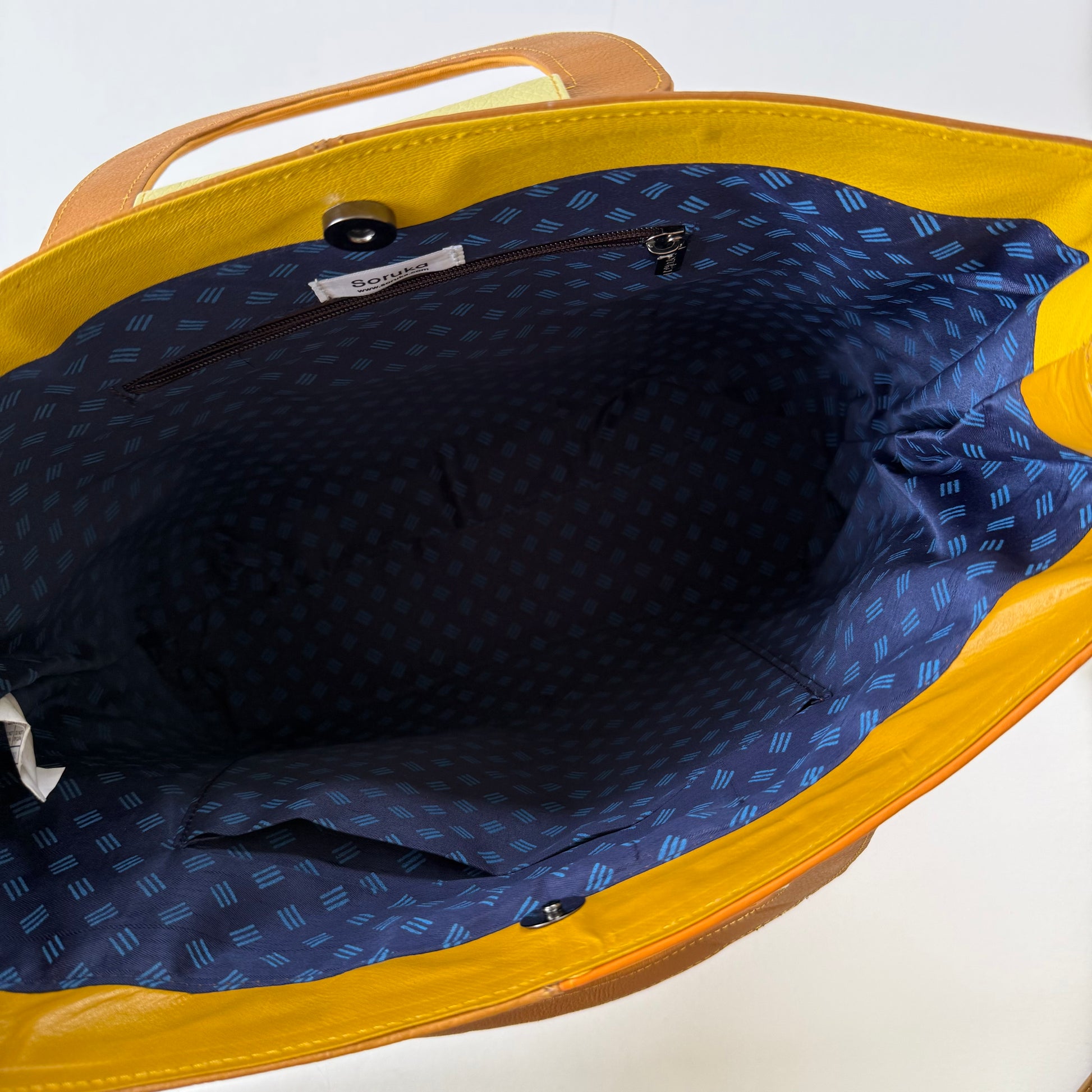 interior view of tote bag with navy patterned lining and pockets