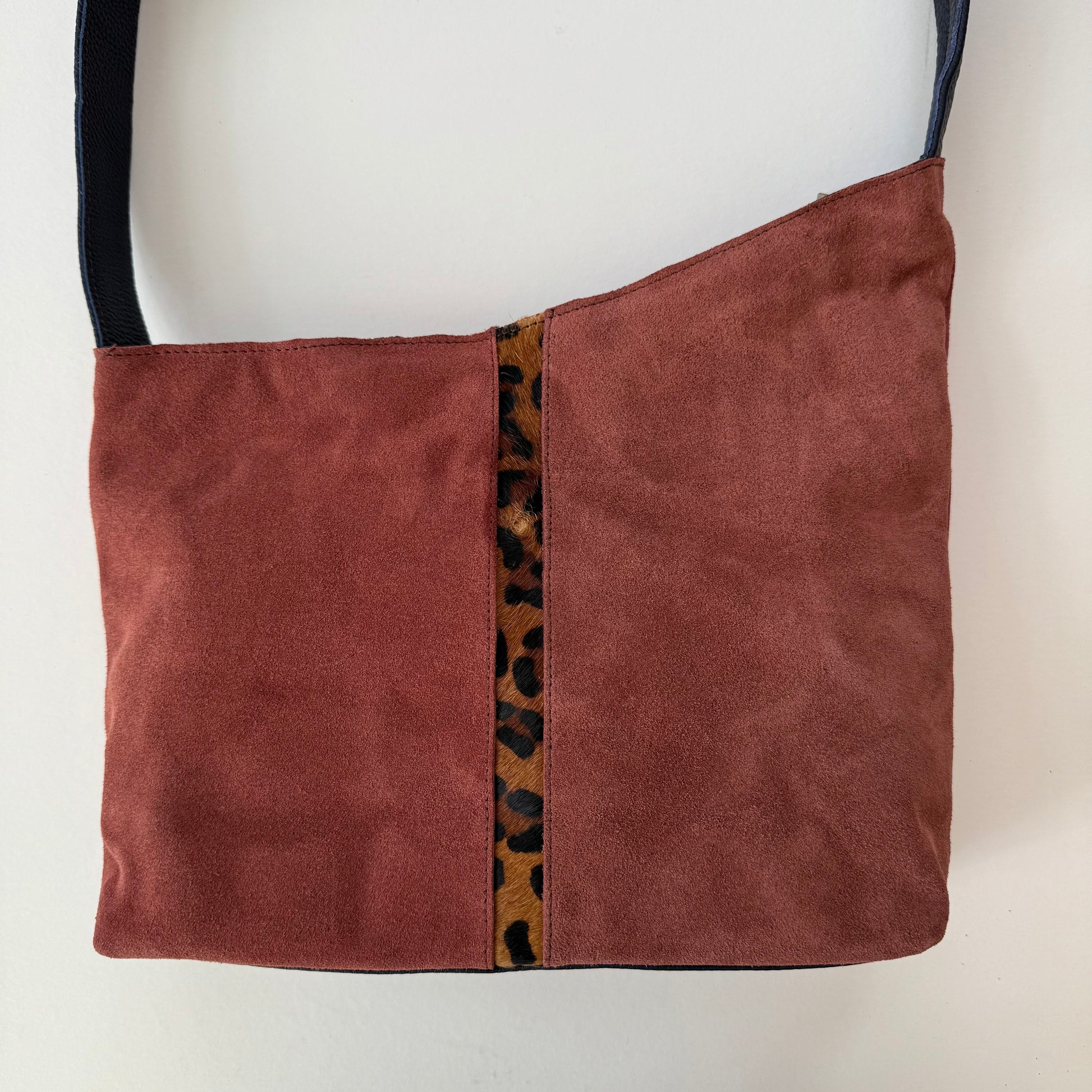 muted burgundy handbag with leopard print accent on a white background