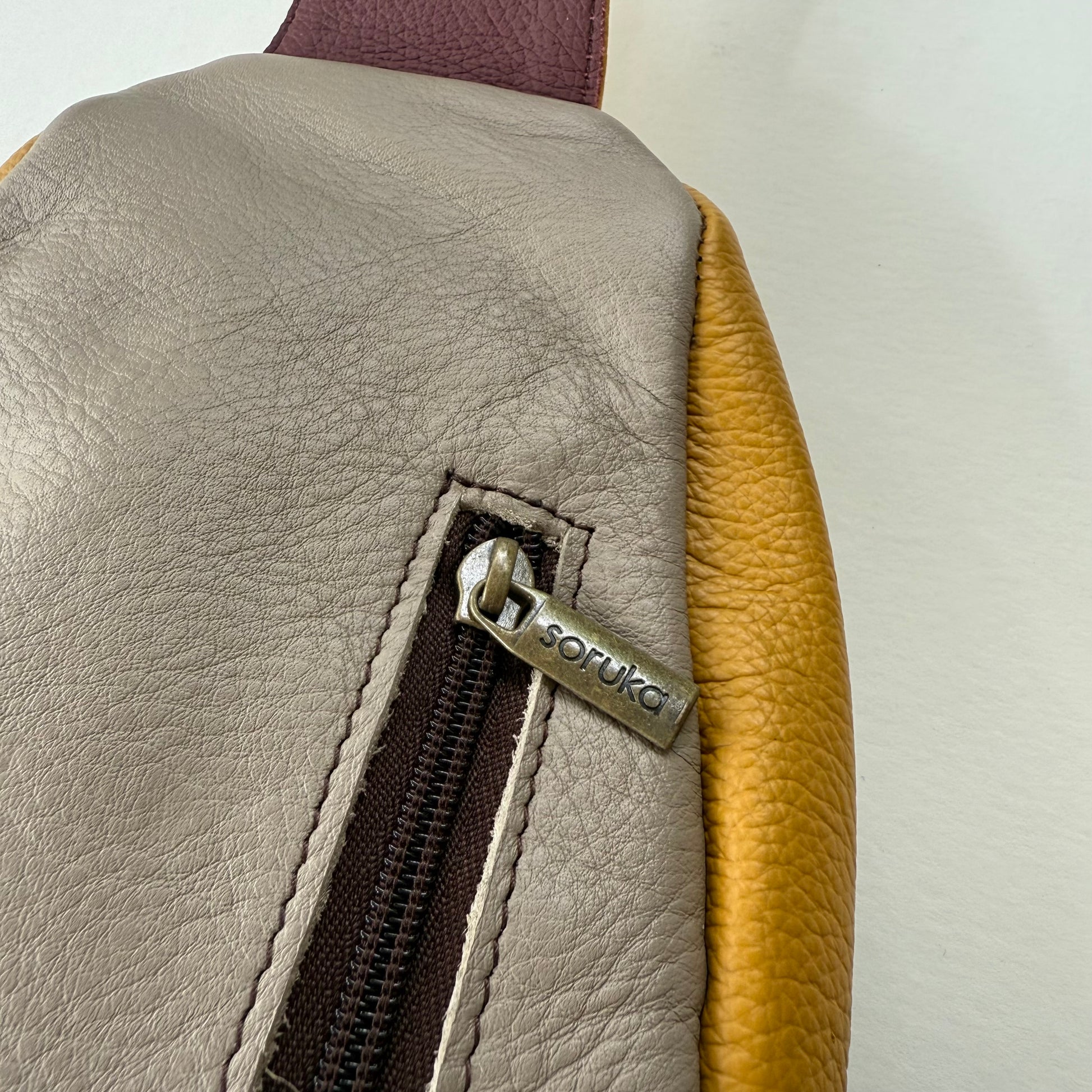 close-up of zipper pocket of back of sling bag