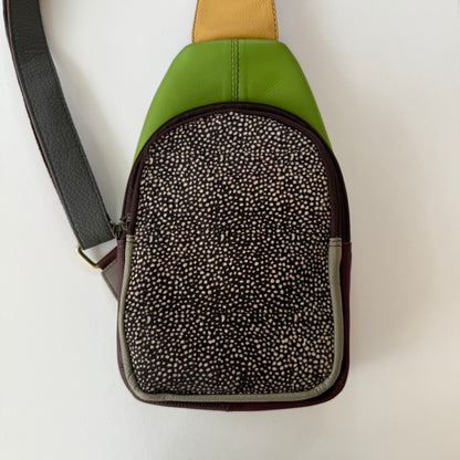 Green and black patterned sling bag bag on a white background