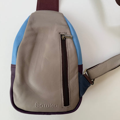 back view of grey sling bag with zippered pocket