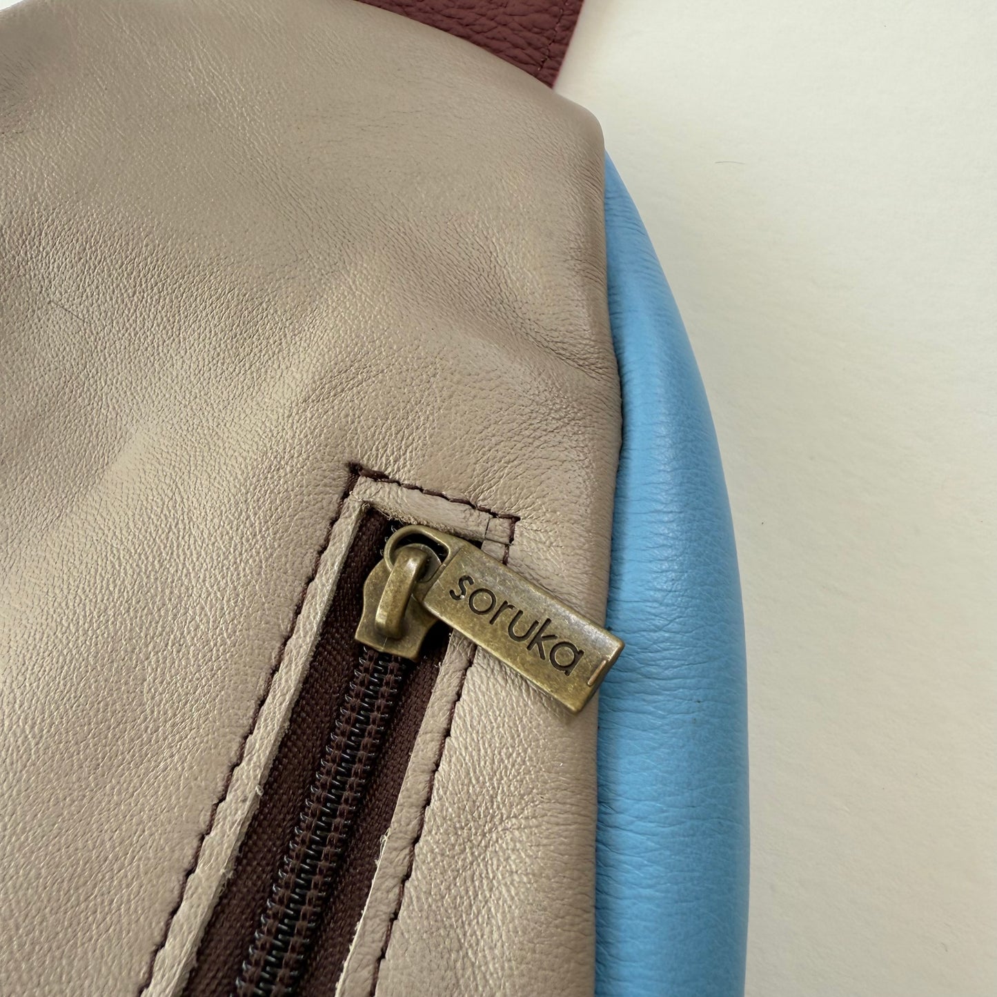 close-up of zipper pocket on back of sling bag