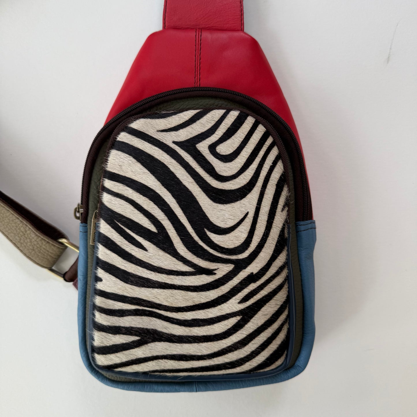 Red and blue sling bag with zebra pattern front on a white background