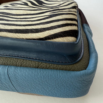 close-up of bottom corner of multi-colored sling bag