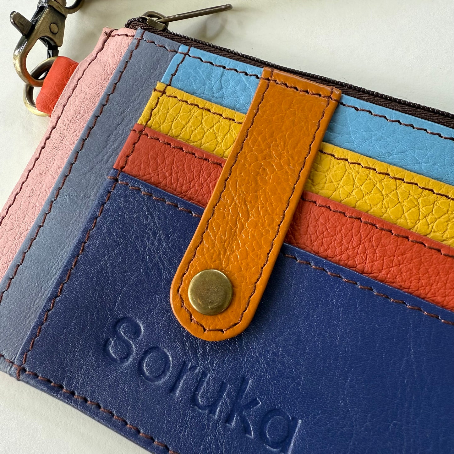 close-up of wallet with snapped tab over colorful card slots
