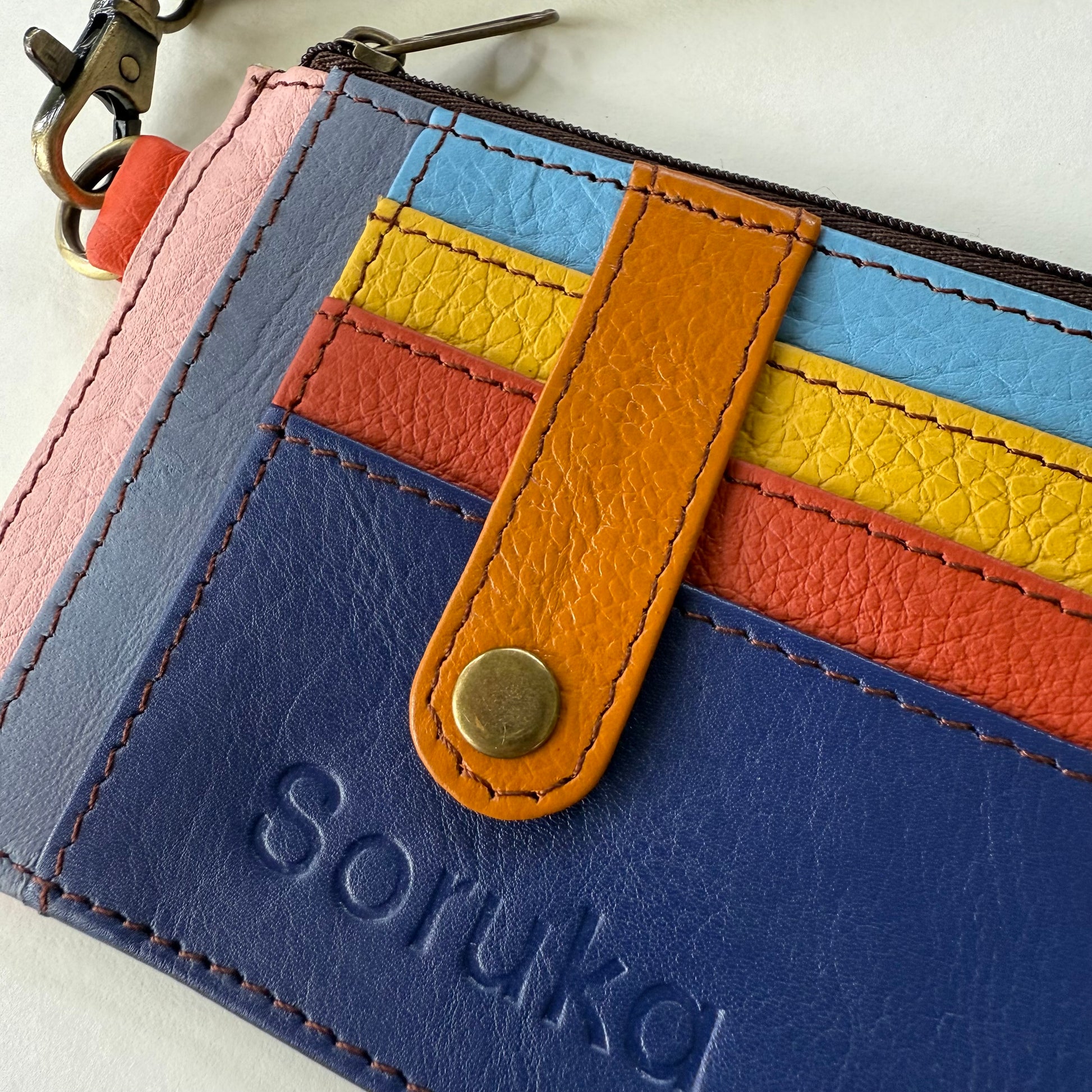 close-up of wallet with snapped tab over colorful card slots
