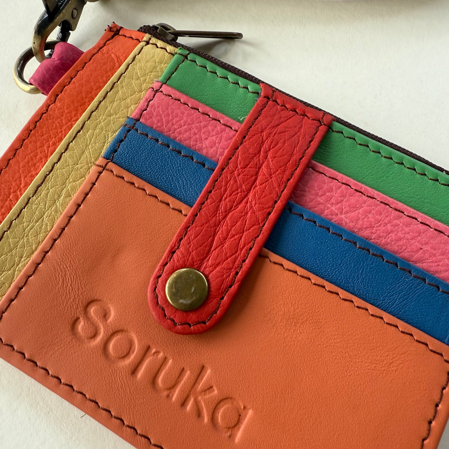 close-up of wallet with snapped tab over colorful card slots
