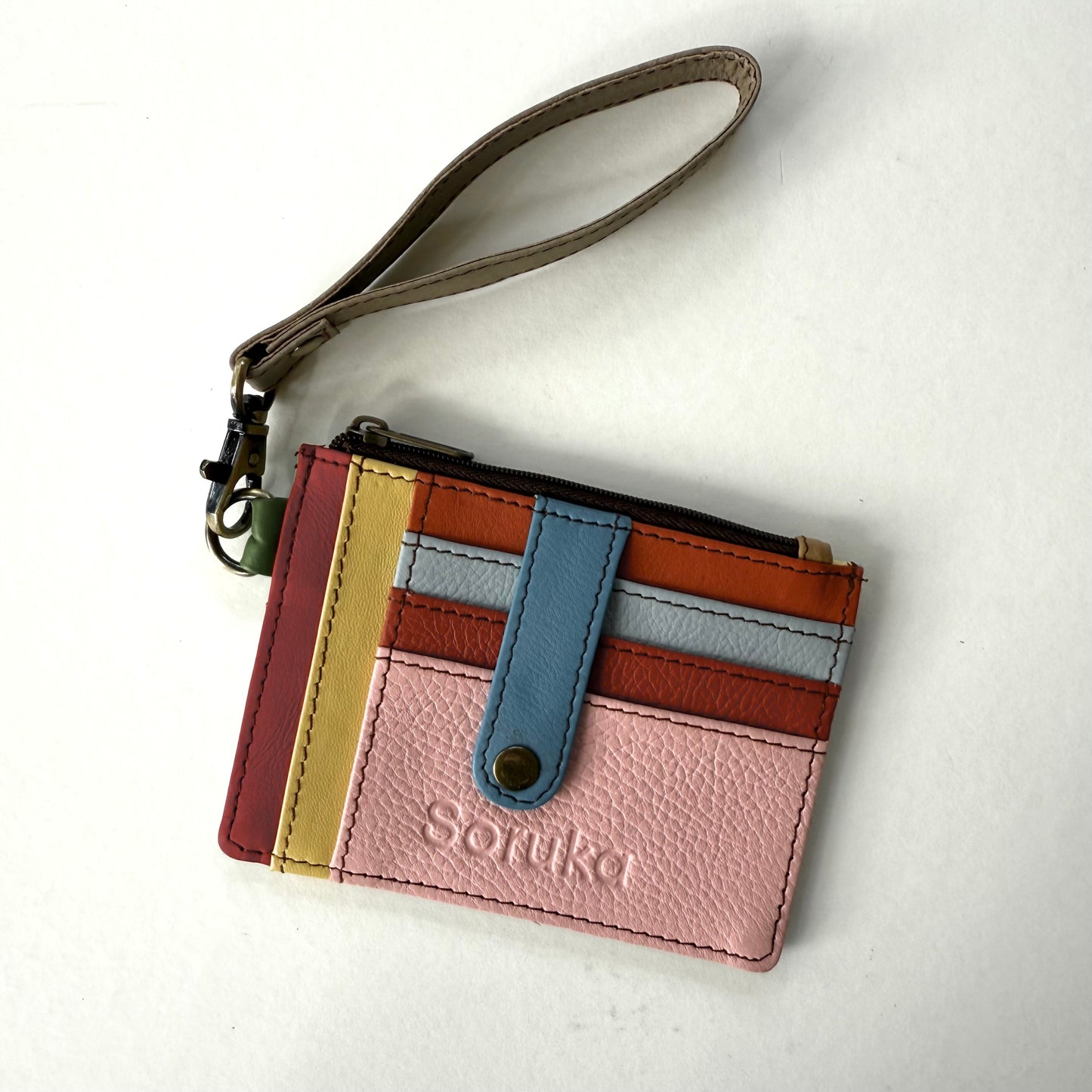 small wallet with colorful card slots, a blue tab, and taupe wristlet strap
