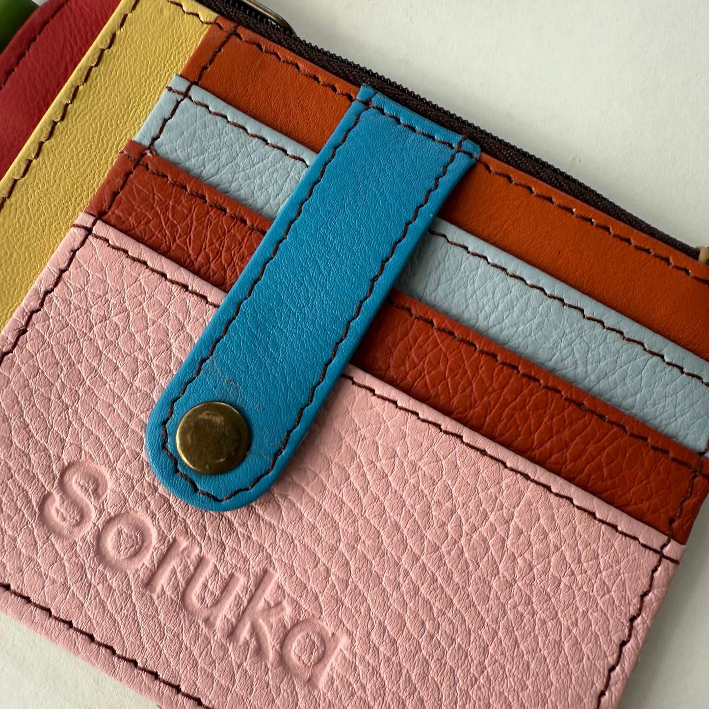 close-up of wallet with snapped tab over colorful card slots
