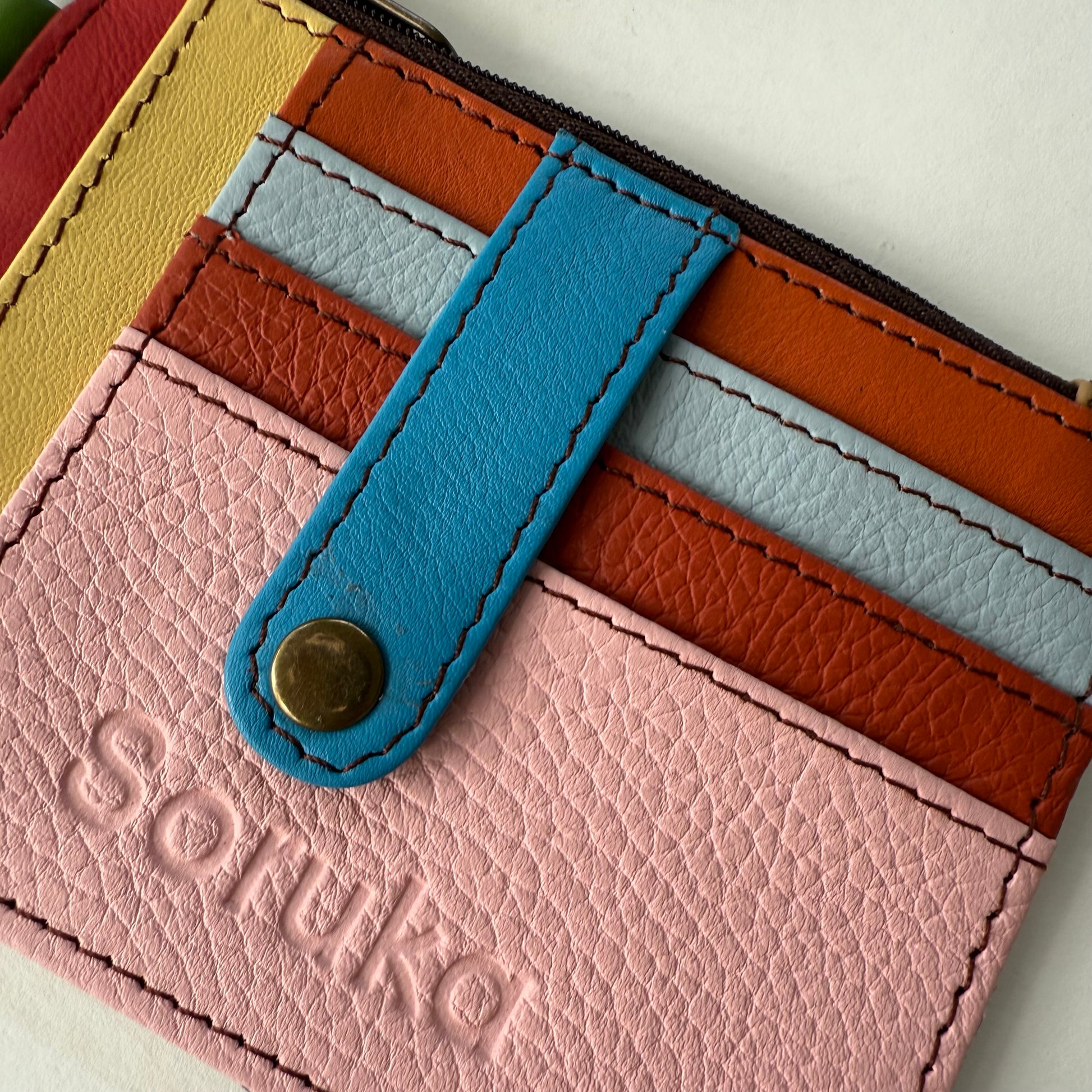 close-up of wallet with snapped tab over colorful card slots
