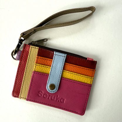small wallet with colorful card slots, a light blue tab, and taupe wristlet strap
