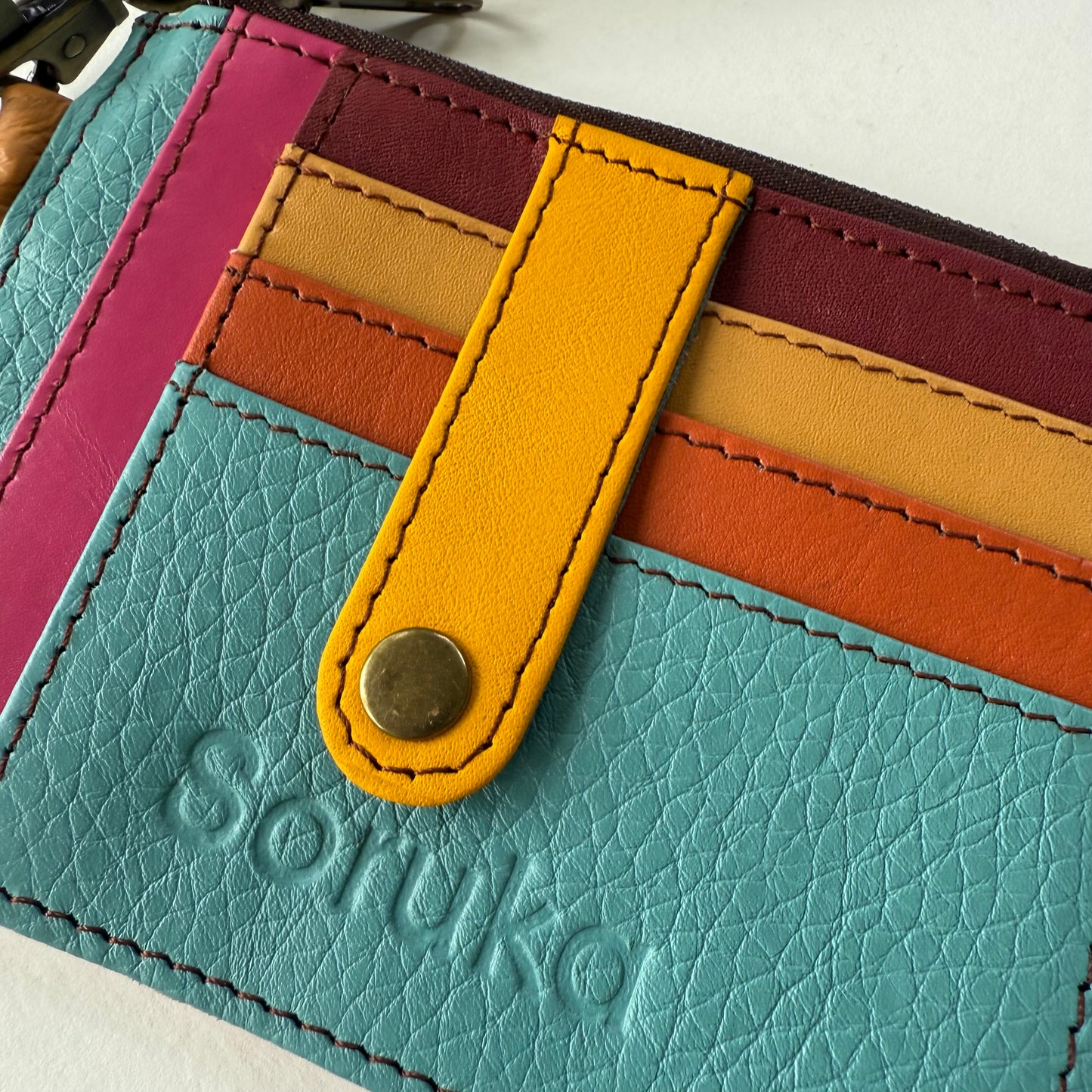 close-up of wallet with snapped tab over colorful card slots
