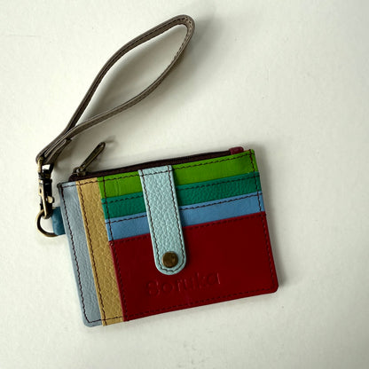 small wallet with colorful card slots, a light blue tab, and dark wristlet strap
