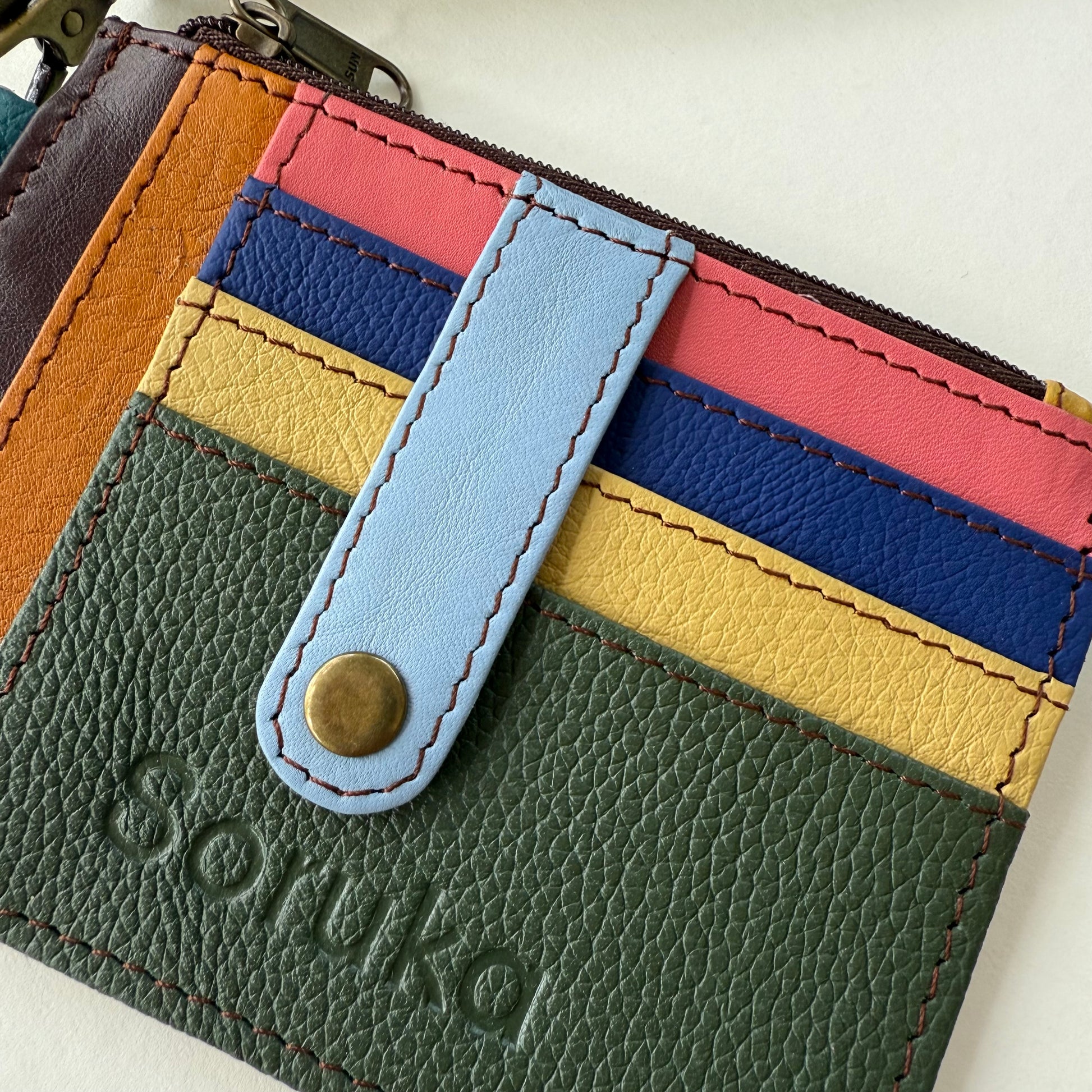 close-up of wallet with snapped tab over colorful card slots
