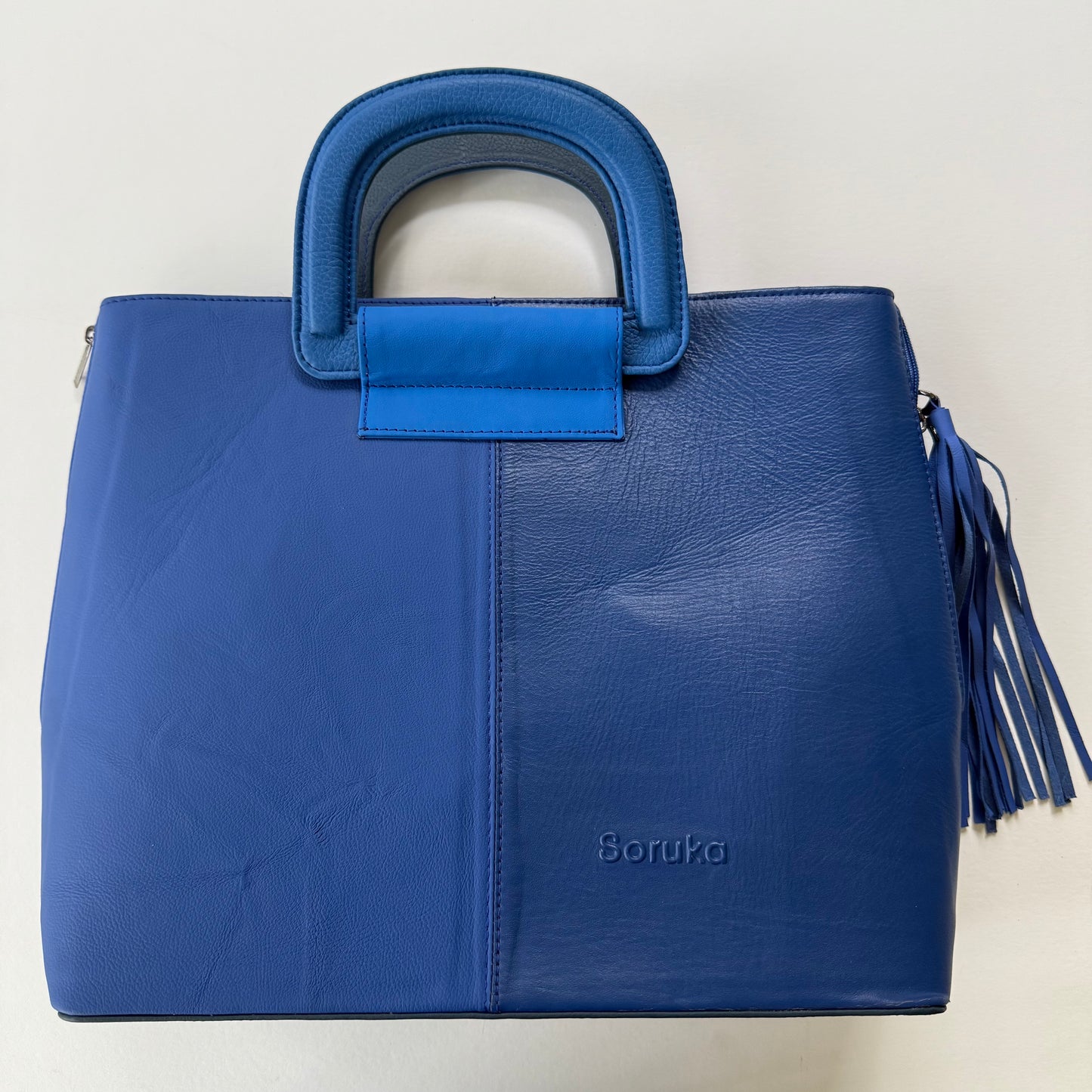 tote bag with several shades of blue and a blue tassel on it