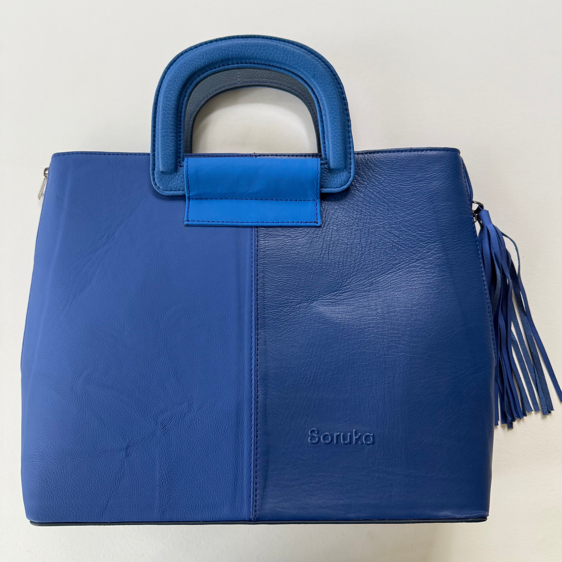tote bag with several shades of blue and a blue tassel on it