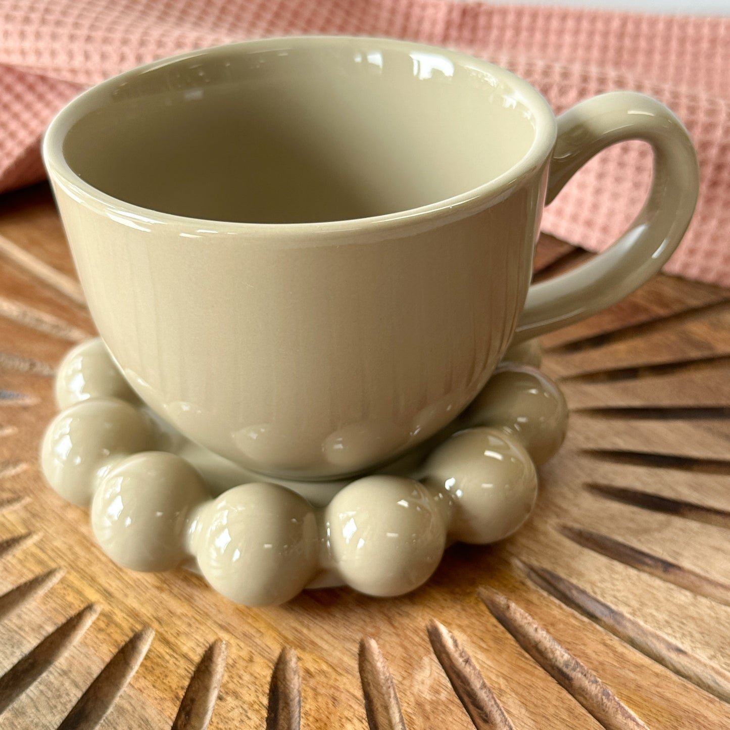 taupe Stoneware Mug with Bubble Saucer set on a wooden board