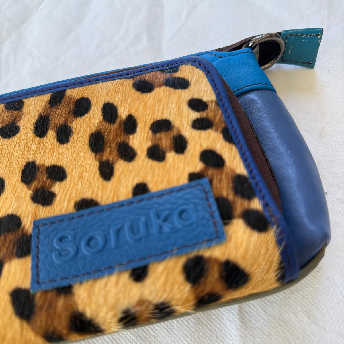 close-up of blue crossbody with leopard front pocket