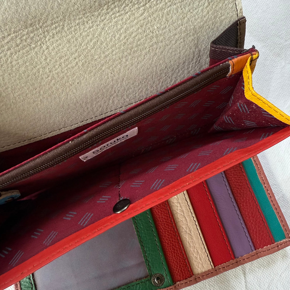 interior view of wallet with colorful card slots, cash slip pockets and zippered coin pocket