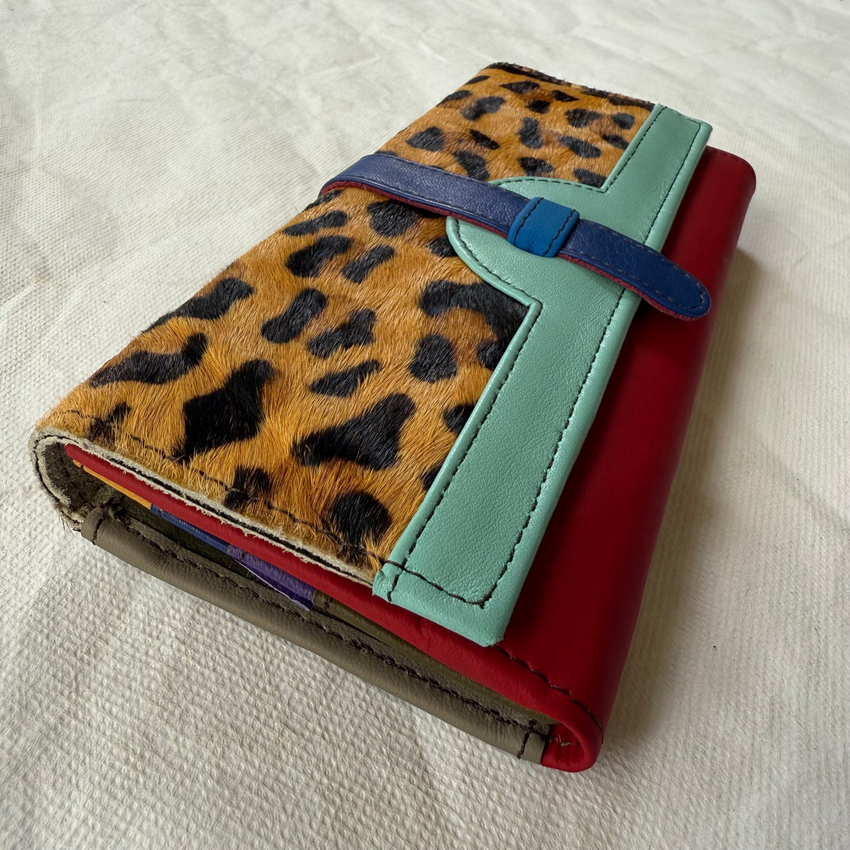 side view of wallet with leopard print flap an red body