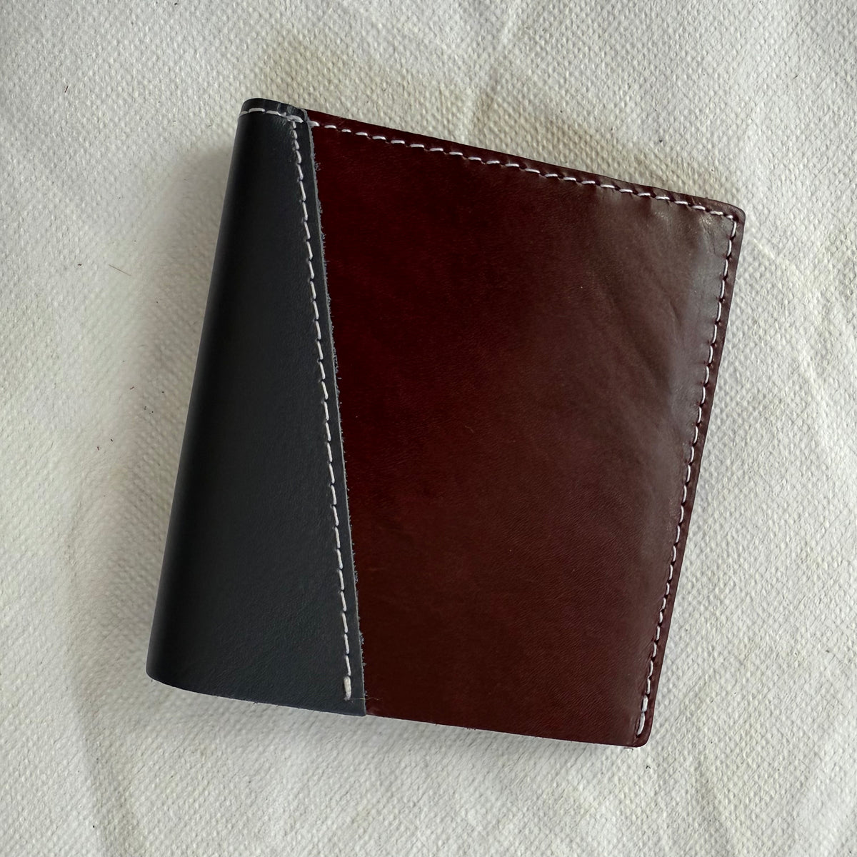 wallet with burgundy and grey leathers and white stitching