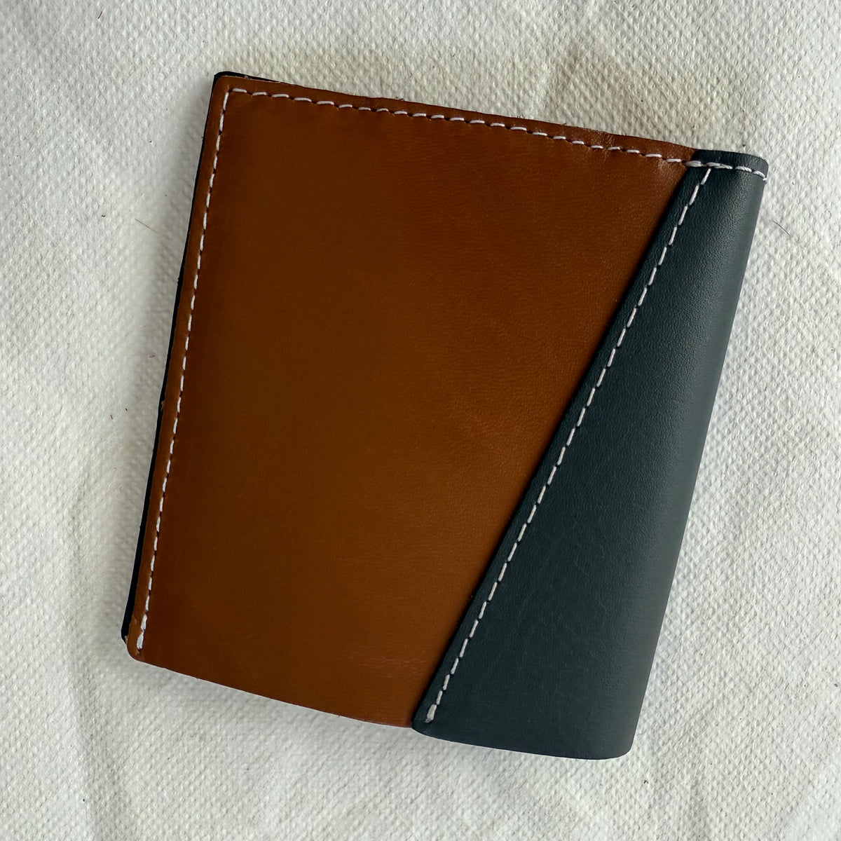 other side of wallet with brown and blue leathers and white stitching
