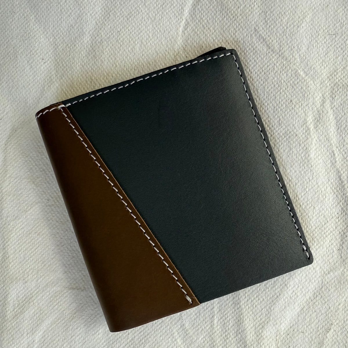 wallet with dark grey and brown leathers and white stitching