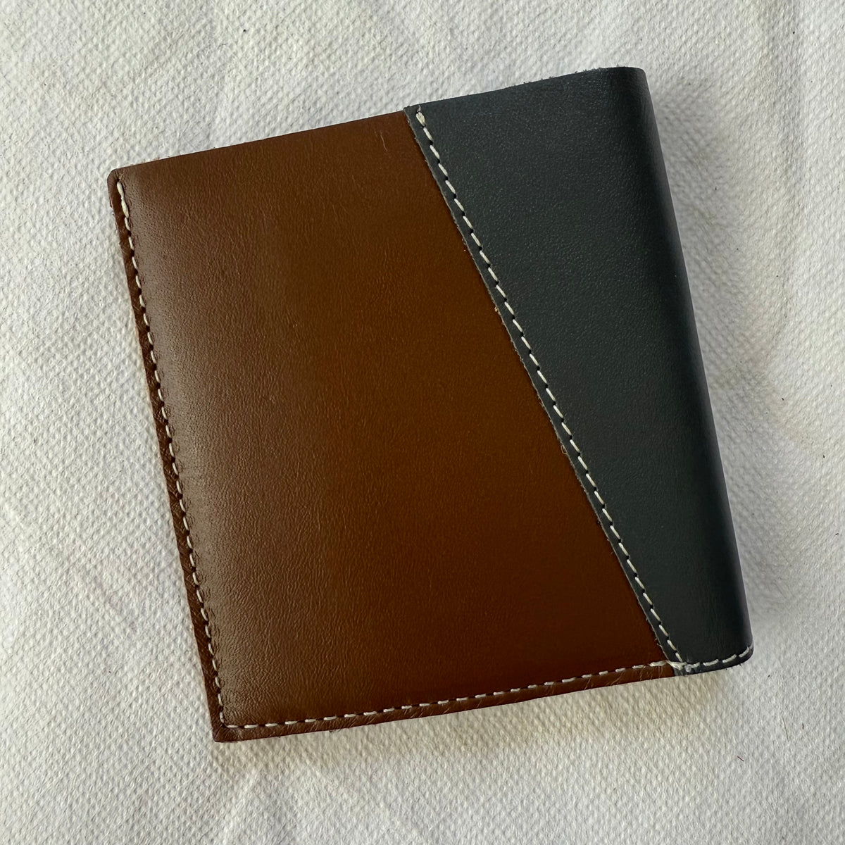 other side of wallet with brown and blue leathers and white stitching