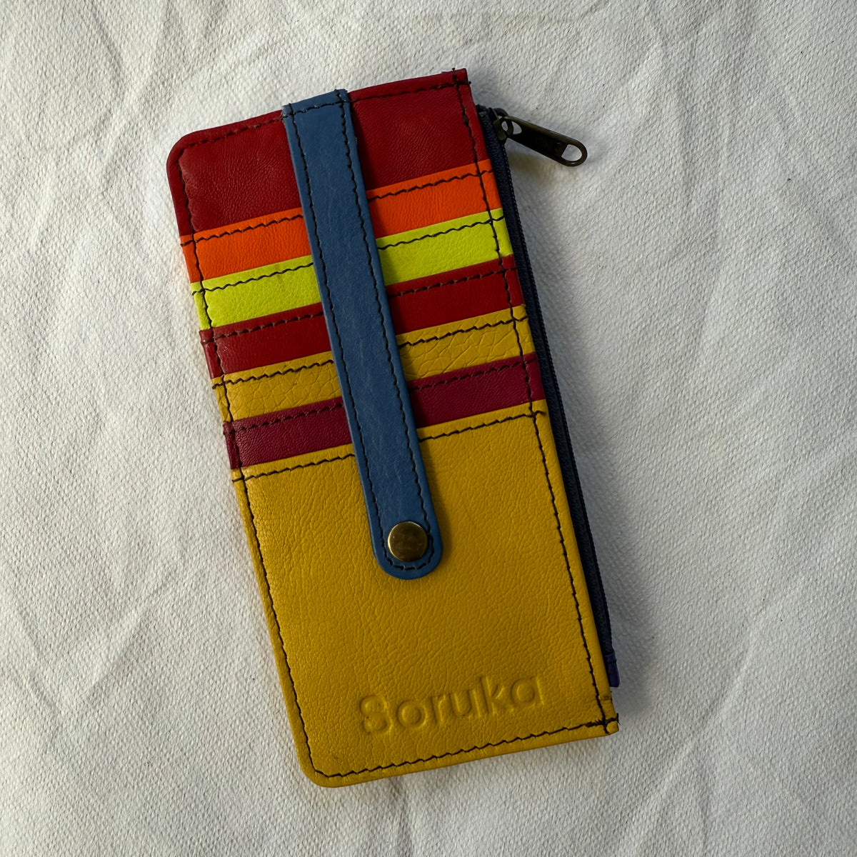 flat wallet with colorful card slots in yellows, reds, and orange and a zip pocket along the side