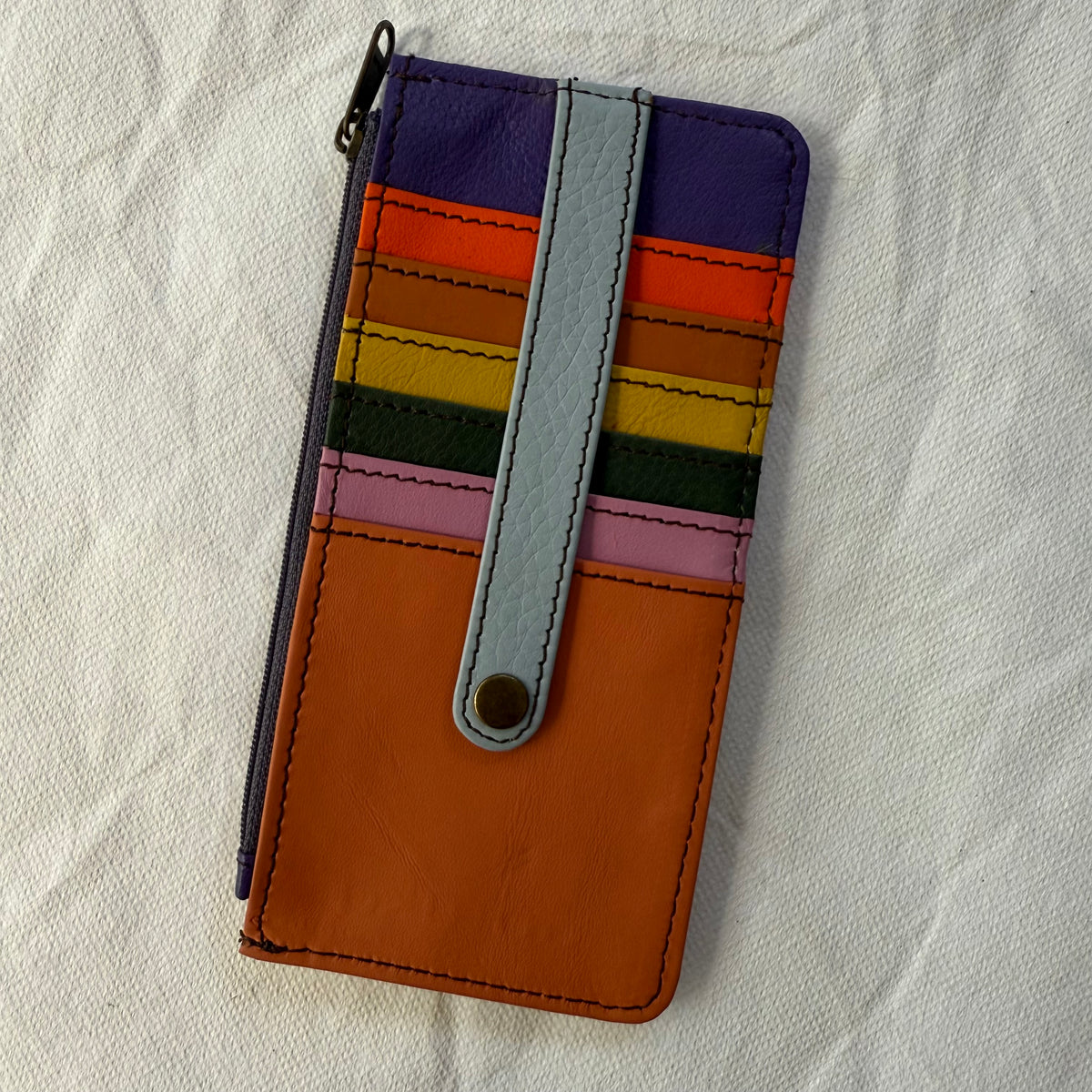other side of flat wallet with colorful card slots and a zip pocket along the side