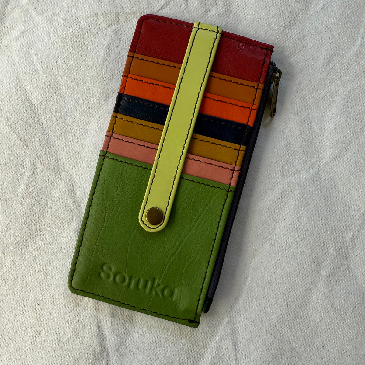 flat wallet with colorful card slots in green, brown, and yellow and a zip pocket along the side